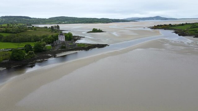 A wide shot of the sandy bay, showing an old Irish castle along the Atlantic coast. Doe Castle, Co. Donegal, Ireland