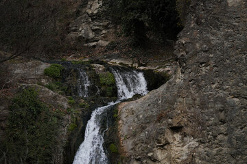 Beautiful waterfall in the botanical garden in Georgia, Tbilisi,сloseup of the water flowing over rocks 