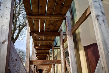 Wooden scaffolding. Repair of the building facade.