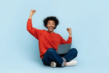 Gardinen Excited man with laptop celebrating © Prostock-studio