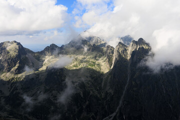 Ladovy stit and Prostredny hrot, view from Slavkovsky stit, High Tatras, Vysoke Tatry, Slovakia. Misty and foggy rocky mountains. Top, peak and summit are partly covered by mist and fog on sunny day.
