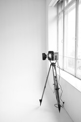 Retro cinema spotlight on a tripod in a photo studio on a white background. Black and white photo