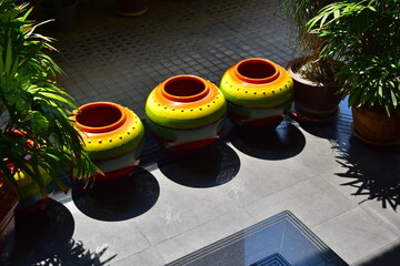 Colorful decorative jugs illuminated by beautiful sunlight in a Thai garden.