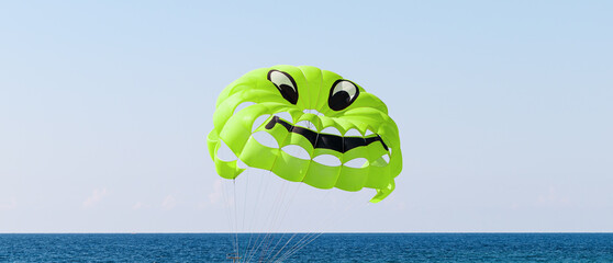 A bright green parachute with a smiley face design. Parasailing in the sea