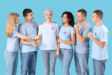 Obraz premium Mature woman after chemotherapy and people with lavender awareness ribbons on blue background. World Cancer Day