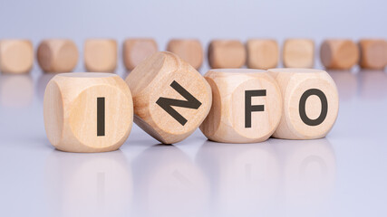 four wooden cubes with the text 'INFO' on a light gray background