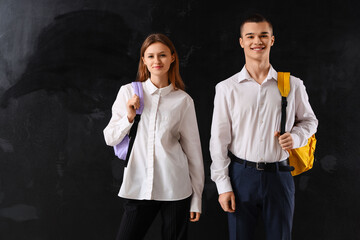 Students with backpacks on blackboard background. End of school concept