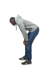 Side view portrait of a crouching man looking down on white background.
