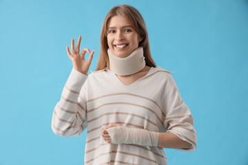 Injured young woman after accident showing OK on blue background