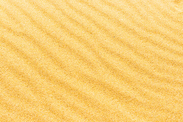 Sand texture on the beach with waves as natural tropical background