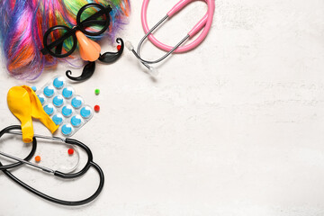 Composition with pills, medical supplies and party decor on light background. April Fool's Day...