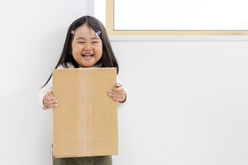 段ボール箱を持つ笑顔の女の子（3歳、日本人） - obrazy, fototapety, plakaty
