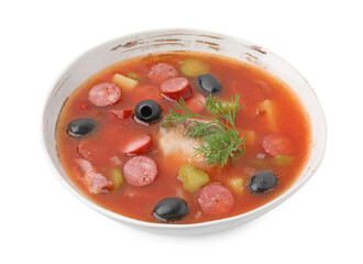 Meat solyanka soup with thin dry smoked sausages in bowl isolated on white