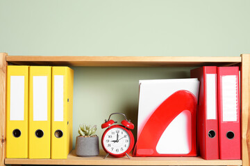 Colorful binder office folders and stationery on shelving unit indoors