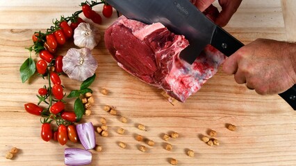 Preparation of Florentine steak: pieces of red Chianina beef on a wooden cutting board in a butcher...