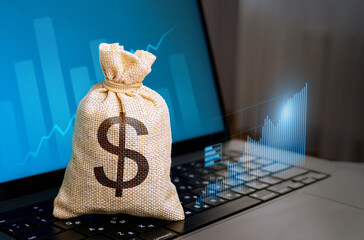Dollar money bag and laptop with growth charts. Make money. Economics of Innovation and High...