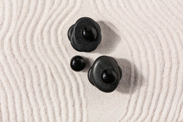Fototapeta na wymiar Stones on sand with lines in Japanese rock garden. Zen concept