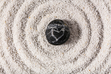Stone on sand with lines in Japanese rock garden, top view.  Zen concept