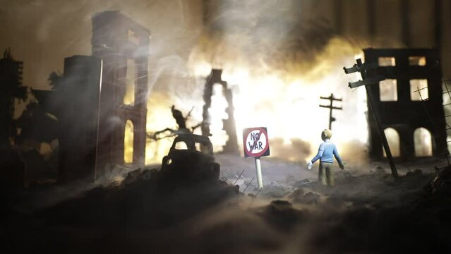 Concept of Peace: No War. A miniature ruined city after a nuclear catastrophe. A 'No War' sign stands beside a shocked person surrounded by the blazing ruins