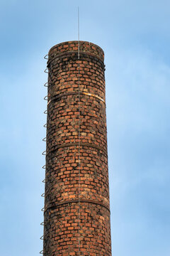 historic factory chimney made of masonry brick with crampons and modern lightning conductor