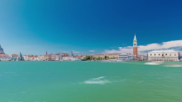 Venice panoramic timelapse with the Giudecca Island, the Madonna della Salute Church, Doge's Palace, St. Marc Square seen from the bell tower of the St. George. Blue cloudy sky at summer day