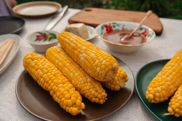 Hot boiled corn with bright yellow grains lies on table. Zea mays. Healthy food corncob from...