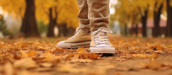 Feet sneakers walking on fall leaves Outdoor with Autumn season nature on background