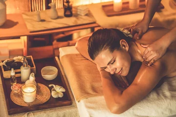 Deurstickers Caucasian woman customer enjoying relaxing anti-stress spa massage and pampering with beauty skin recreation leisure in warm candle lighting ambient salon spa at luxury resort or hotel. Quiescent © Summit Art Creations