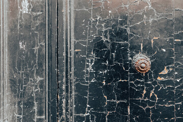 Old black paint texture close up on a closed door in a ruined building