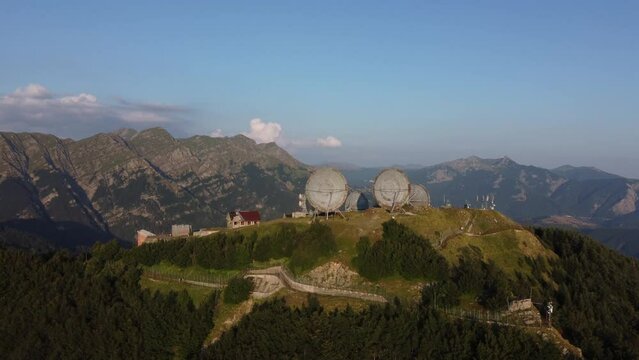 Aerial view of the big parabolic antenna of the NATO radio station abandoned on the top of Monte Giogo, used during cold war. Comano, Massa and Carrara province, Lagastrello lake, Tuscany, Italy. 