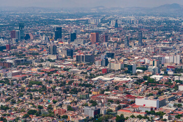 Aerial view of the Mexico City Skyline featuring the skyscrapers of Avenue De Reforma with the mountains in the background