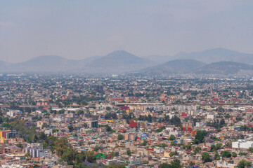 Aerial view of the Mexico City Skyline featuring the skyscrapers of Avenue De Reforma with the mountains in the background