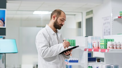 Healthcare workers monitoring pharmaceutical packs on racks and managing store inventory to...