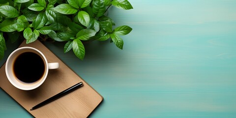 Coffee cup with notebook and plant on blue wooden background. - obrazy, fototapety, plakaty