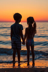 Silhouette of two children holding hands on the beach at sunset, during the golden hour light. National Siblings day