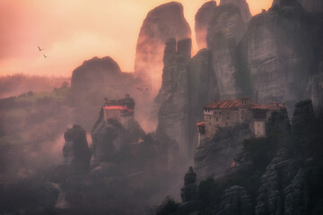 Beautiful misty moment in the rocks of Meteora in Greece at sunset surrounded with monasteries and flying birds.  - obrazy, fototapety, plakaty