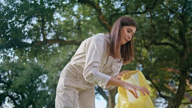 Volunteer cleaning garbage park holding bag. Woman collecting plastic trash