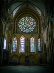 Fototapeta na wymiar Lincoln Cathedral, Roman Catholic Gothic church and cathedral with stain glass window corridor and hall, with arches, columns, pews, vault, aisles, gallery, arcades and clerestory.