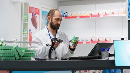 Medical retail clerk scanning supplies to register new stock, working at drugstore checkout counter...