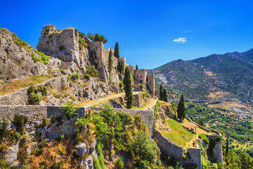 Summer landscape - view of the ruins of the Klis Fortress, near Split on the Adriatic coast of Croatia - obrazy, fototapety, plakaty
