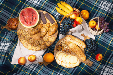 View of different food for summer picnic on checkered blanket, flat lay. The concept of summer outdoor recreation on the weekend