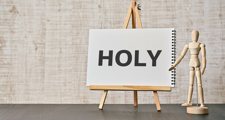 There is notebook with the word HOLY. It is as an eye-catching image. - obrazy, fototapety, plakaty