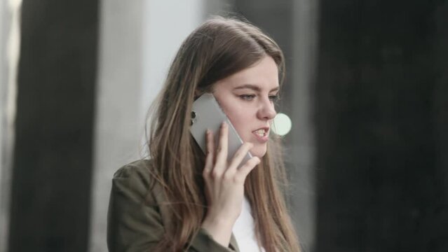 Irritated arguing young businesswoman yelling at mobile phone at city centre Angry nervous female talk on smartphone expressing negative emotion outdoors Bad conflict working or personal conversation