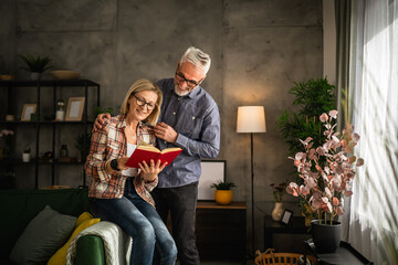 Fototapeta na wymiar mature senior couple man and woman husband and wife read book at home