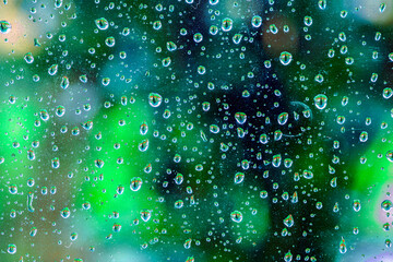 Water drops on a green glass - refreshing detail of bright water drops on a green glass in nature