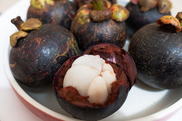 Tropical fruit mangosteen in a white plate, stock photo.