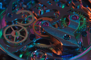 Close up detail of a macro clockwork inside a shiny iron wristwatch with sapphire rear glass bottom.