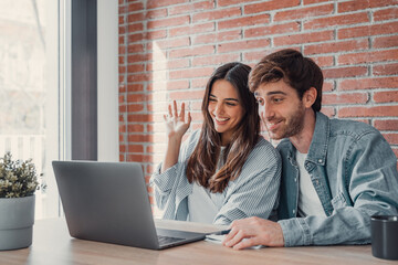 Happy young couple laughing watching funny video or comedy movie online, cheerful man and woman...