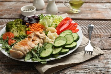 Balanced diet and healthy foods. Plate with different delicious products on wooden table