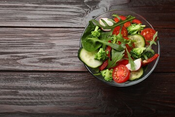 Tasty fresh vegetarian salad on dark wooden table, top view. Space for text